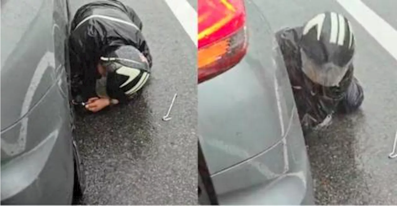 Man helps stranded woman along highway in heavy rain