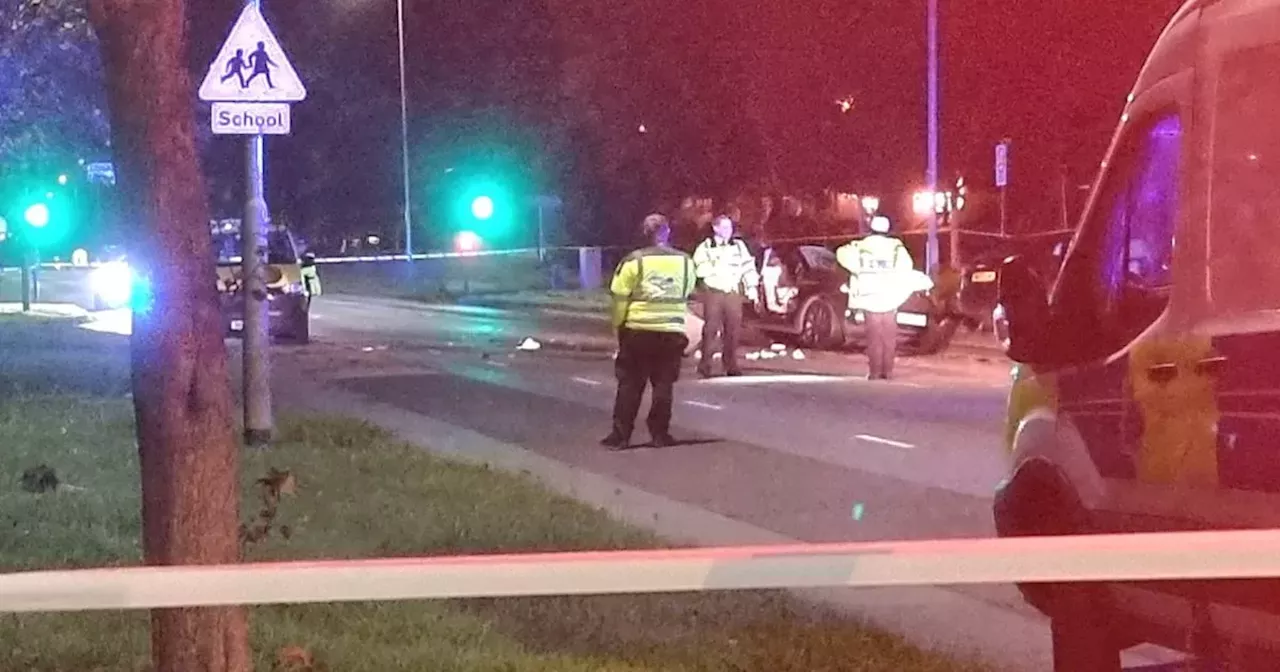 Two injured as person cut out of car following crash on main road