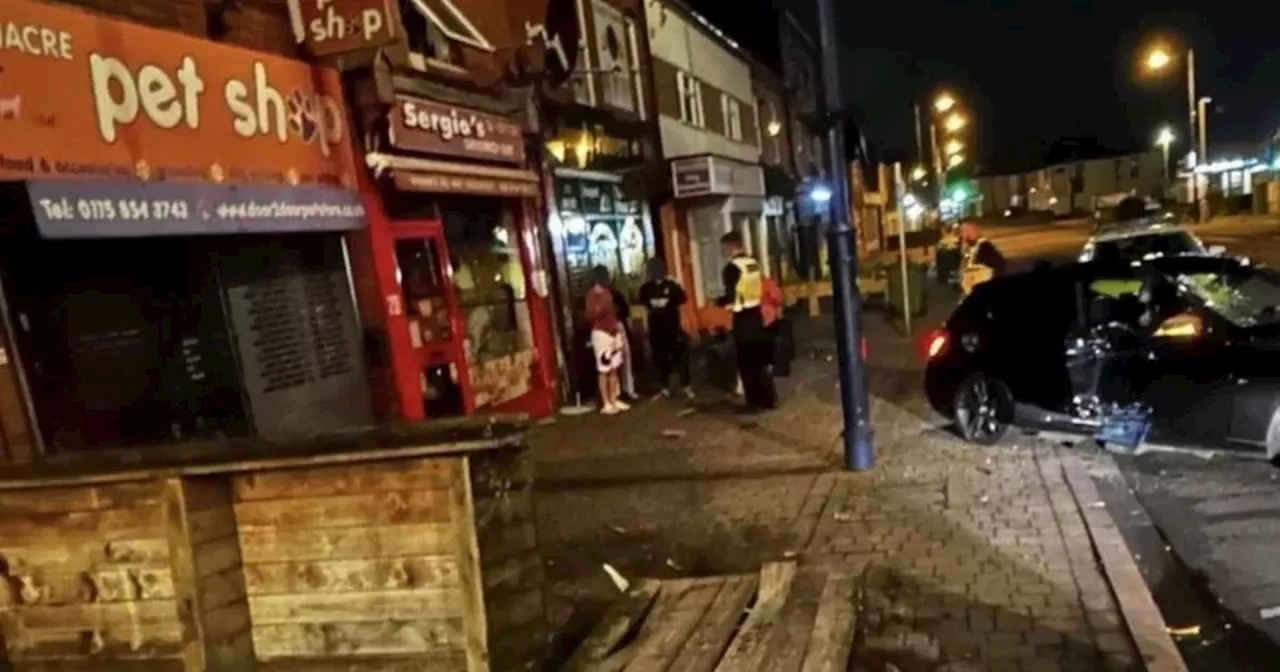 BMW car crashes into two shops in late-night police incident