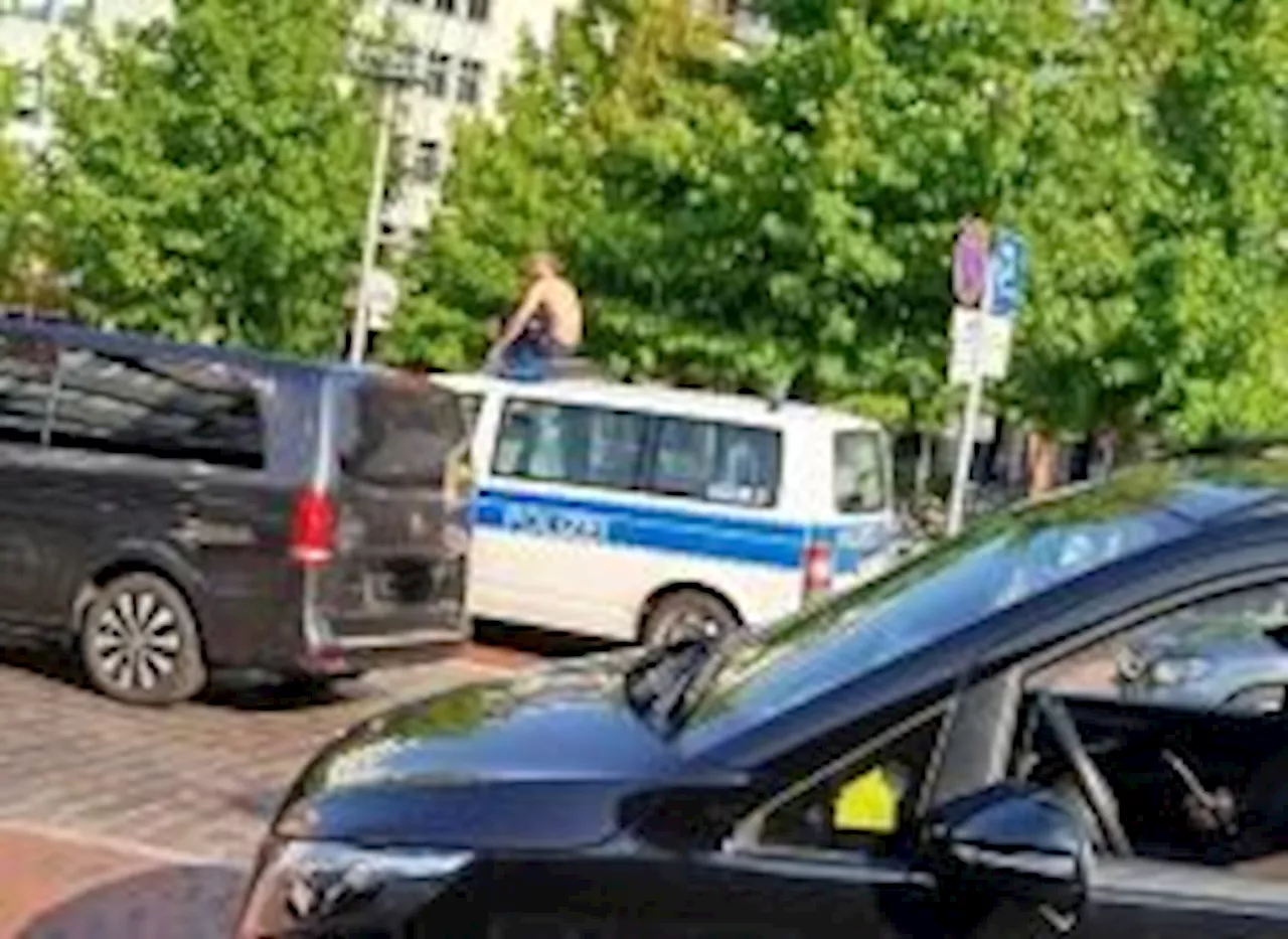 Mann macht es sich auf Streifenwagen der Bundespolizei gemütlich