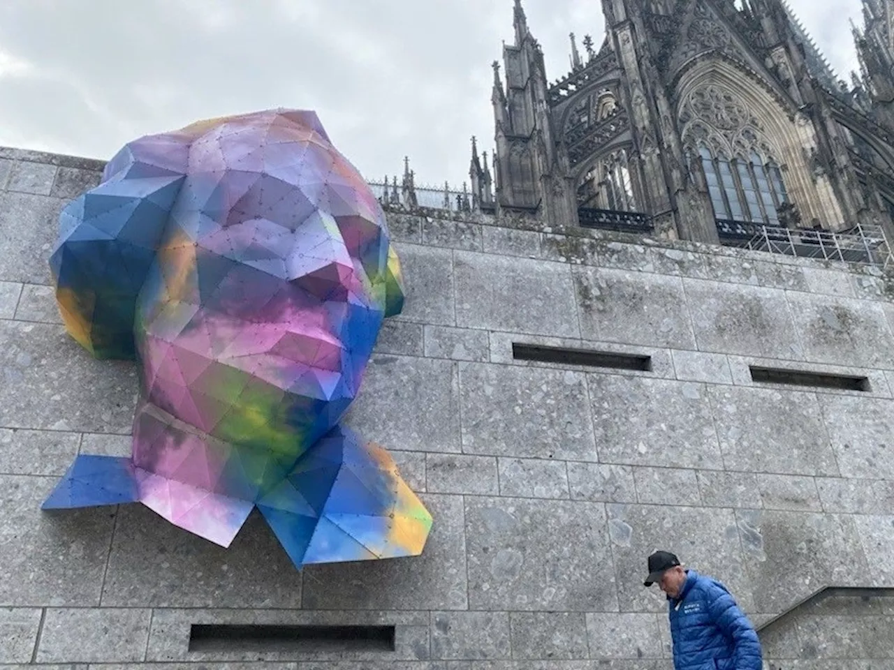 Wer ist der bunte Mann an der Kölner Domtreppe?