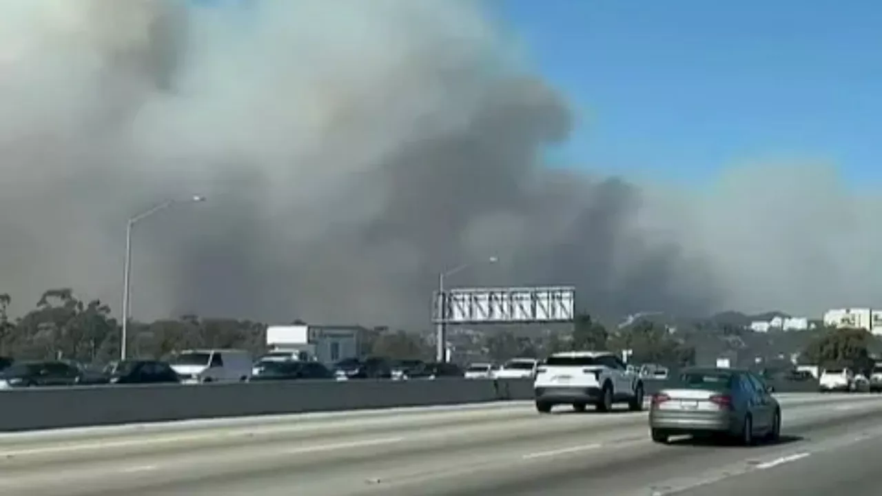 Terrified residents trapped in gridlock traffic as they try to escape LA wildfires after flames surround...