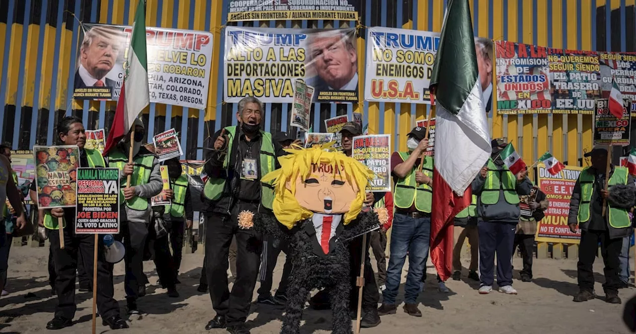 Migrantes protestan en muro fronterizo de Tijuana y rompen piñata de Donald Trump