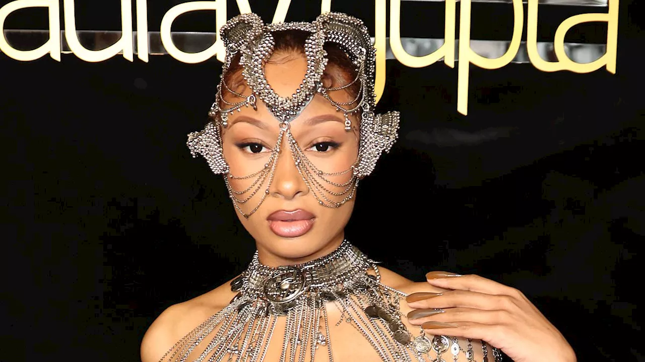 Megan Thee Stallion turns heads in an alien-esque chain-link dress and matching headpiece as she...