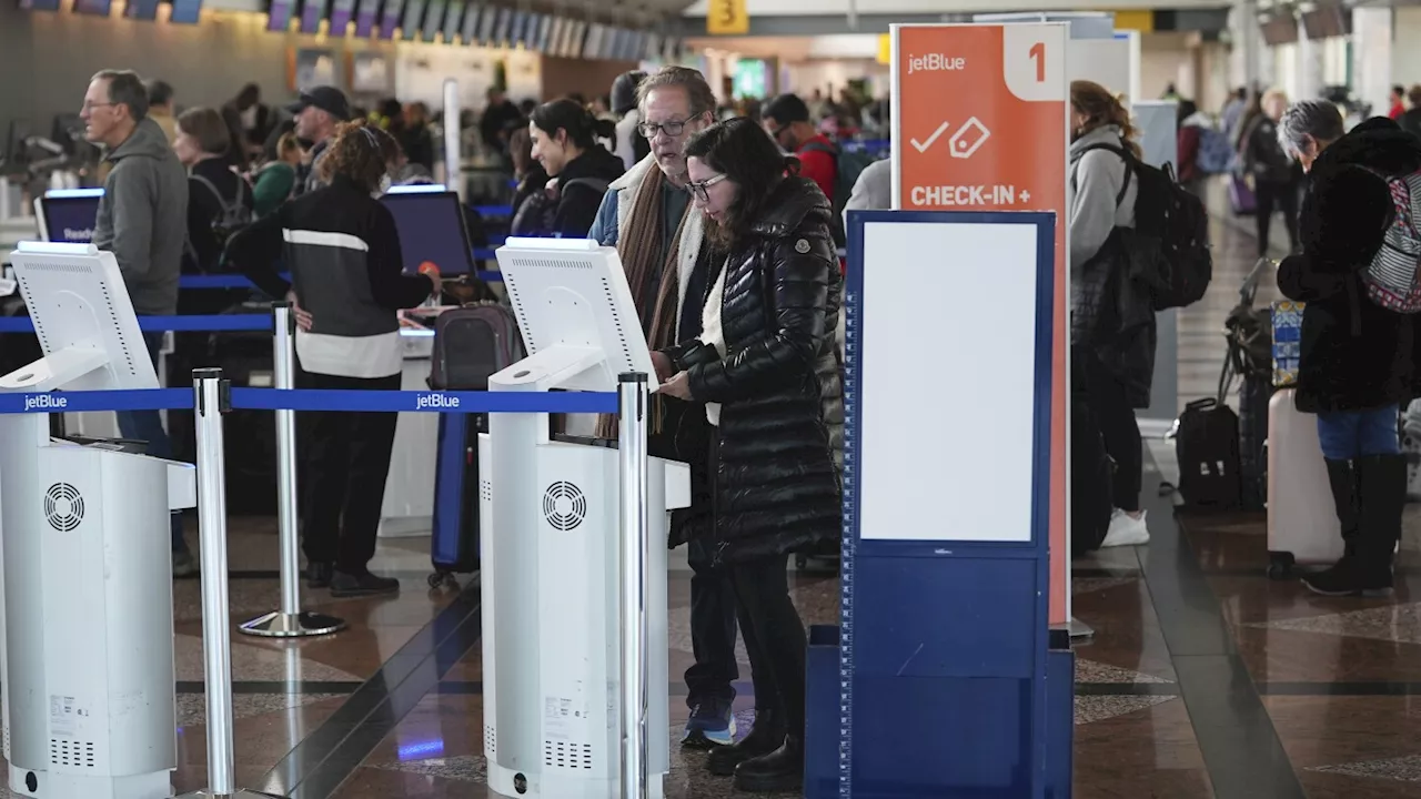 Travellers queue up at Jet Blue Airlines self-check-in kiosks in Denver International Airport