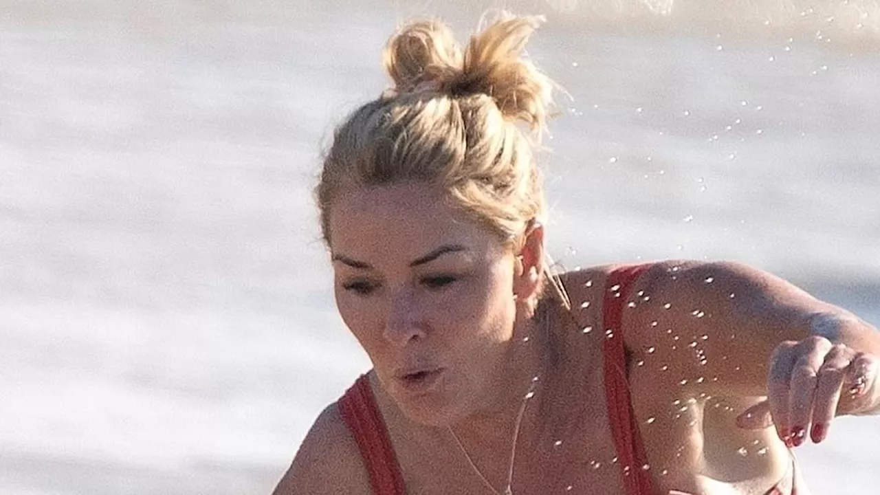 Claire Sweeney almost takes a tumble as she struggles to get out of the water while showing off her...