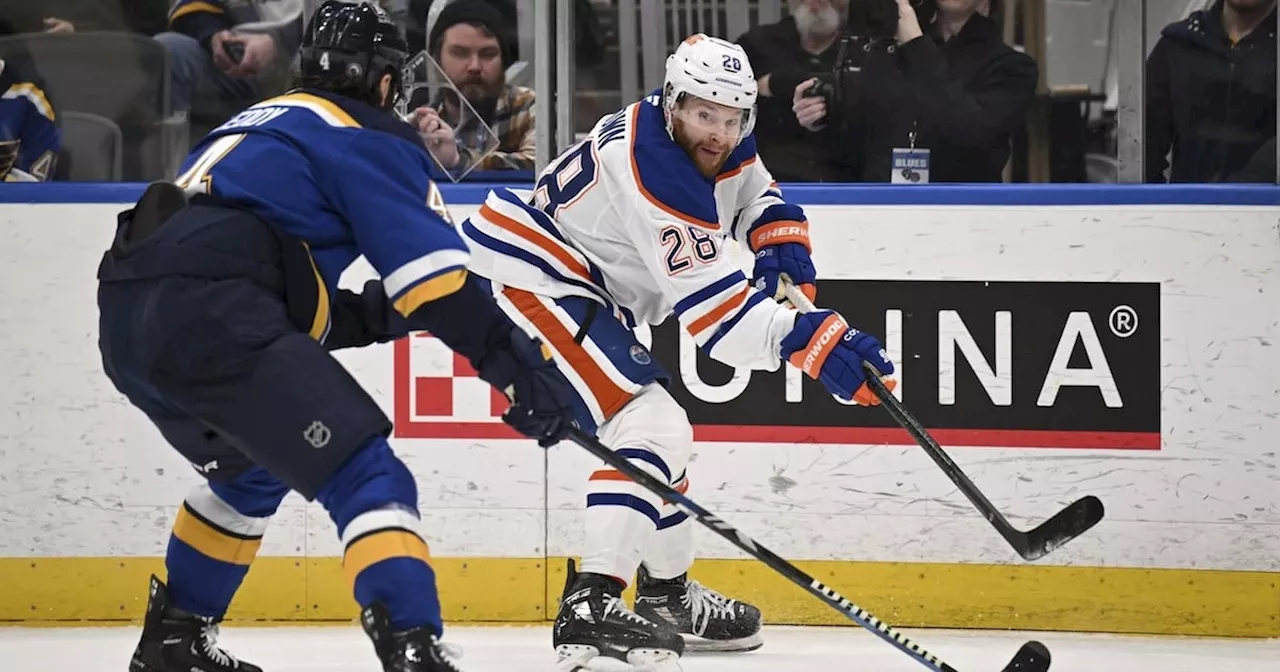 Edmonton Oilers' Connor Brown, right, passes the puck as St. Louis Blues' Nick Leddy, left, defends during the first period of an NHL hockey game Tuesday, Feb. 4, 2025, in St. Louis.