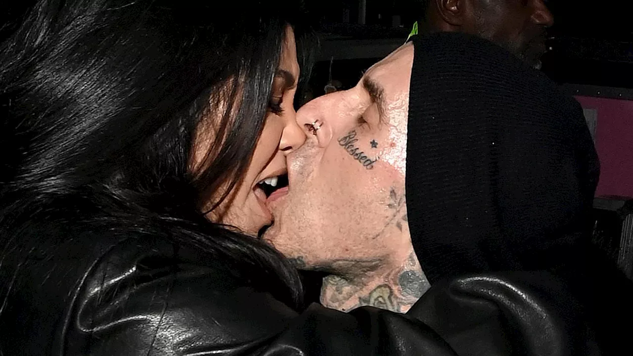 Kourtney Kardashian French kisses husband Travis Barker before jumping in his arms at Super Bowl...