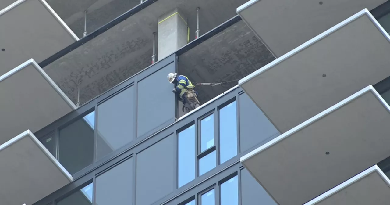 Earthquake shakes high-rise under construction with workers on top level