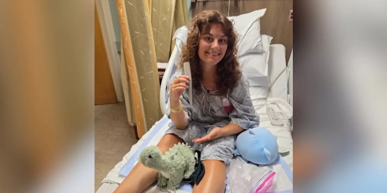 Lifeguard impaled by umbrella shares photo from hospital bed holding piece of pole that went through her