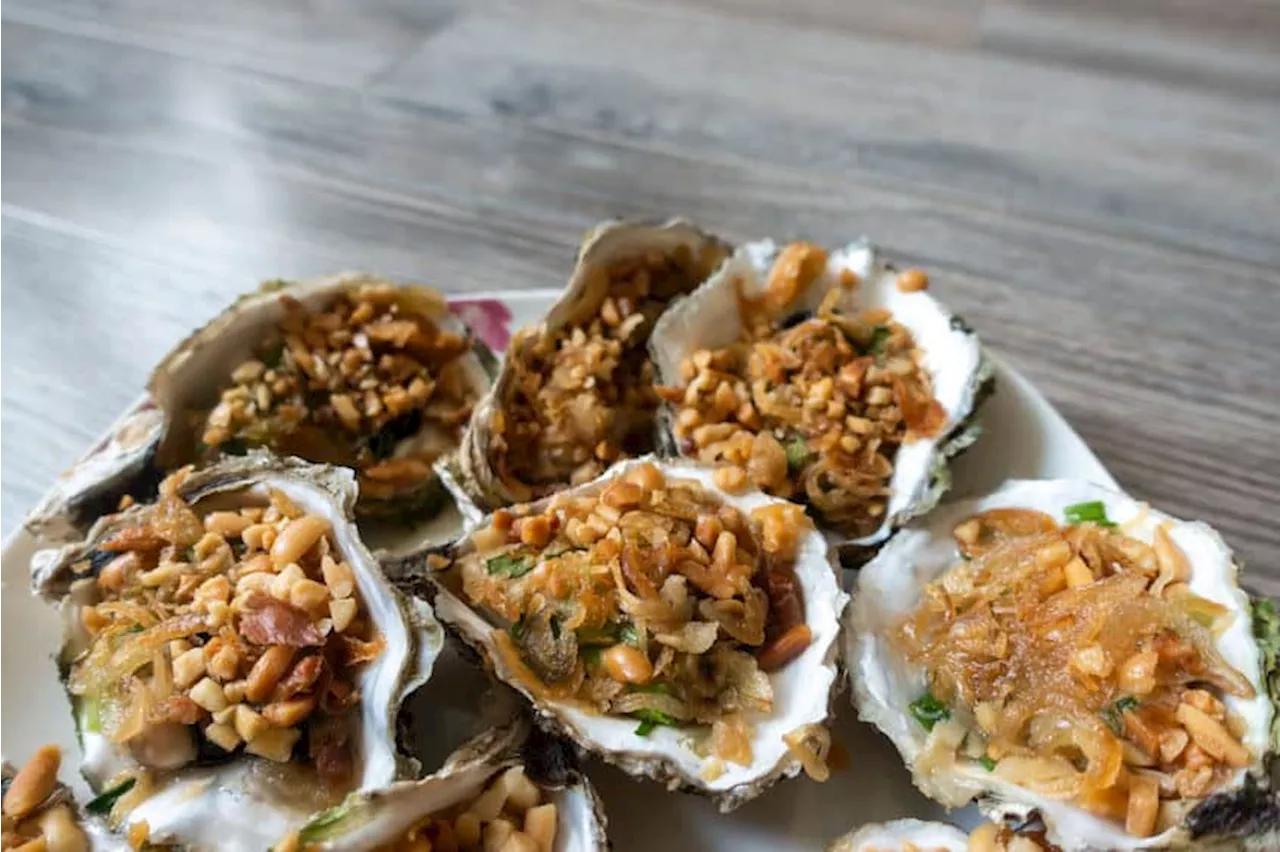 Grilled oysters with green onion, roasted peanut and garlic oil